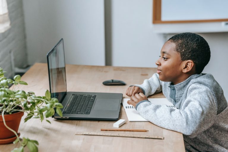 young black boy watching a video on a laptop